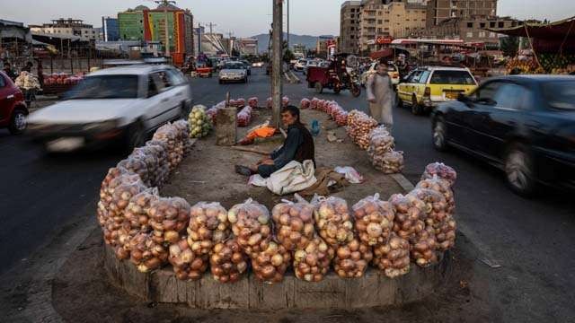 Seorang pedagang sayuran dan kentang menggelar dagangannya di marka di tengah jalan Kota Kabul, Afghanistan. Kota Kabul mulai hidup dan bising, setelah hampir dua bulan senyap.(Foto: Bernat Armangue/Foto AP/Al Jazeera)