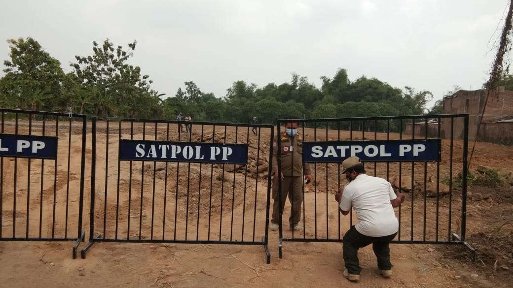 Satpol PP Kota Mojokerto menghentikan pengurukan lahan Ruang Terbuka Hijau (RTH). (Foto: Deni Lukmantara/Ngopibareng.id))
