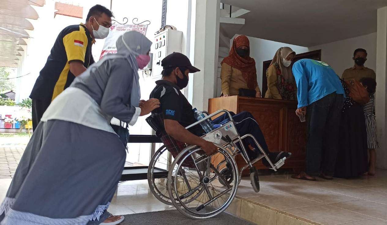 Seorang penyandang disabilitas yang menggunakan kursi roda harus bersusah payah saat hendak masuk ke dalam ruang khusus Gedung DPRD Banyuwangi karena ruangan ini belum ramah disabilitas (foto: Muh Hujaini/Ngopibareng.id)