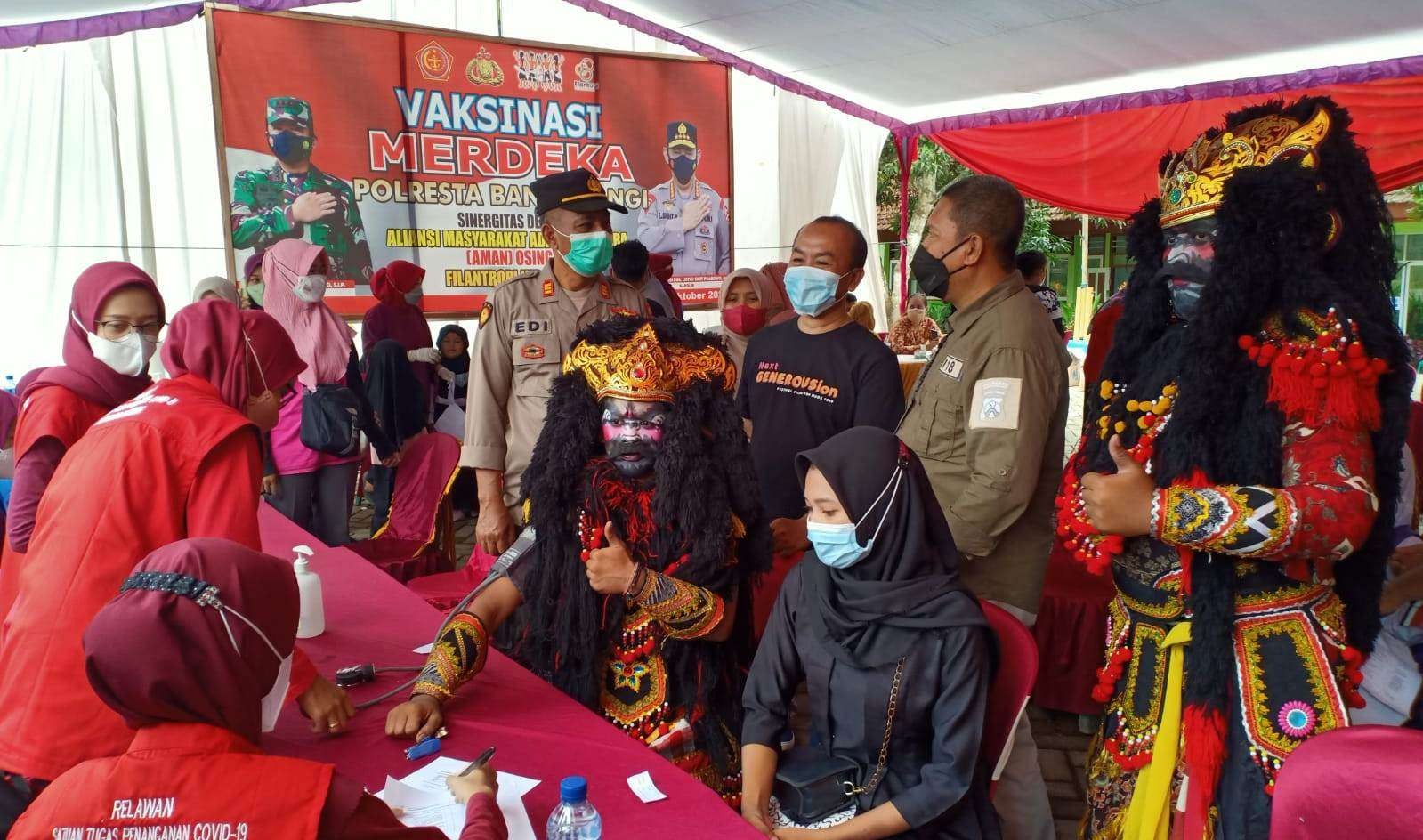 Anggota AMAN mengenakan pakaian Jaranan Buto saat melakukan vaksinasi covid-19 di Desa Macan Putih (foto:istimewa)
