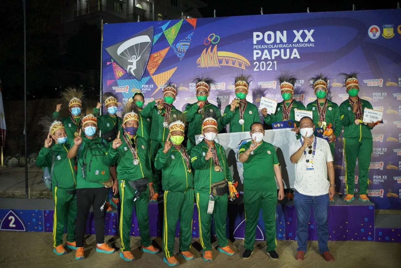 Ketua KONI Jatim, Erlangga Satriagung dan Ketua Harian KONI Jatim M Nabil bersama tim Paralayang Jatim usai merebut gelar juara umum di PON XX 2021 Papua. (Foto: KONI Jatim)