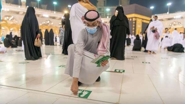Seorang petugas sedang membersihkan stiker tanda pembatasan jarak dari lantai Masjidil Haram di Mekah. Masjidil Haram siap menerima jamaah Umrah. (Foto:Arab News)