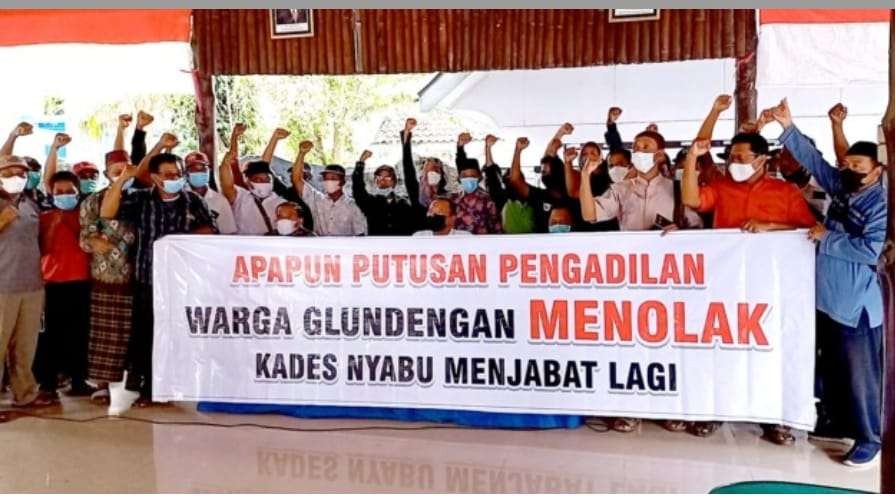 Puluhan perwakilan warga Desa Glundengan dan Tamansari membentangkan banner penolakan kades pecandu sabu menjabat kembali (Foto:Istimewa)