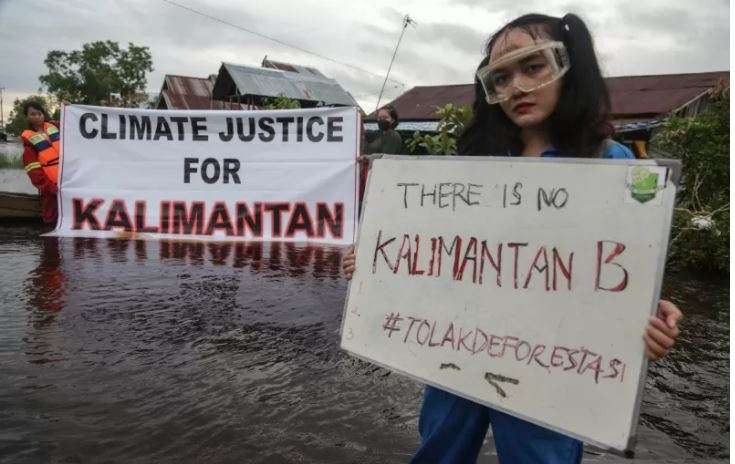 Sejumlah pelajar yang tergabung dalam komunitas Youth Kalimantan melakukan aksi menuntut keadilan iklim di tengah permukiman warga yang terendam banjir di Kalampangan Baru, Palangkaraya, Kalimantan Tengah, Jumat 24 September 2021. (Foto: Antara/Makna Zaezar)