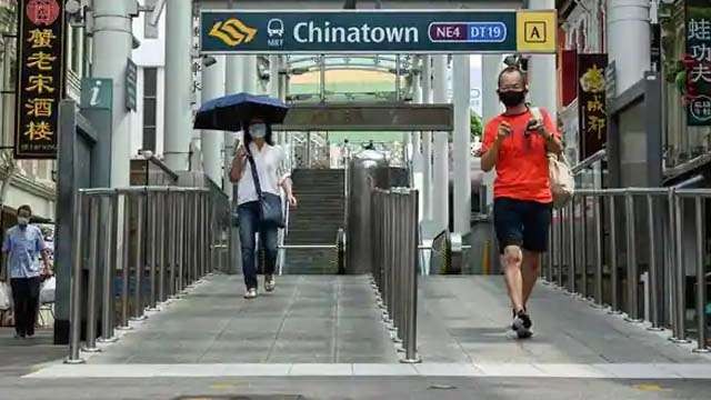 Singapura telah menunda pelonggaran pembatasan, akibat terjadinya peningkatan kasus Cavid-19. Hanya dua orang nampak keluar dari stasiun kereta bawah tanah SMRT di distrik Chinatown, padahal wilayah ini biasanya ramai dengan orang lalu lalang. (Foto:AFP)