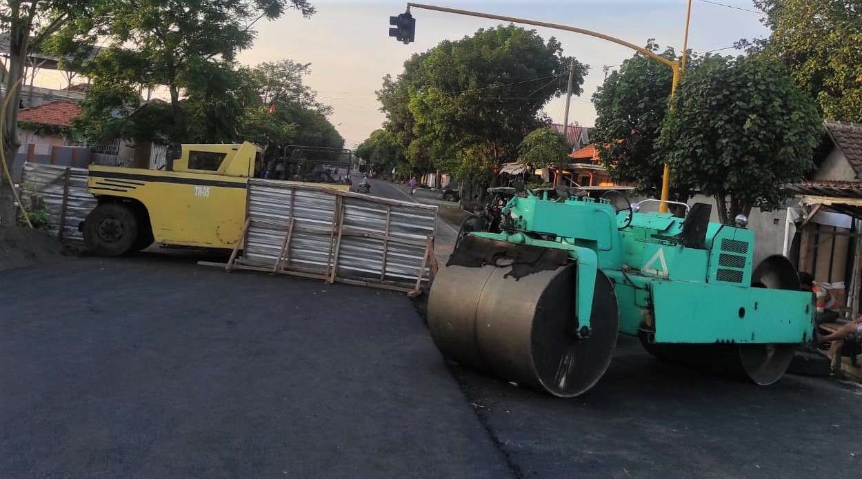 Alat berat disiapkan untuk mengaspal lantai Jembatan Kedungasem, Kota Probolinggo, tetapi DPU Jatim meminta pengaspalan ditunda. (Foto: Ikhsan Mahmudi/Ngopibareng.id)