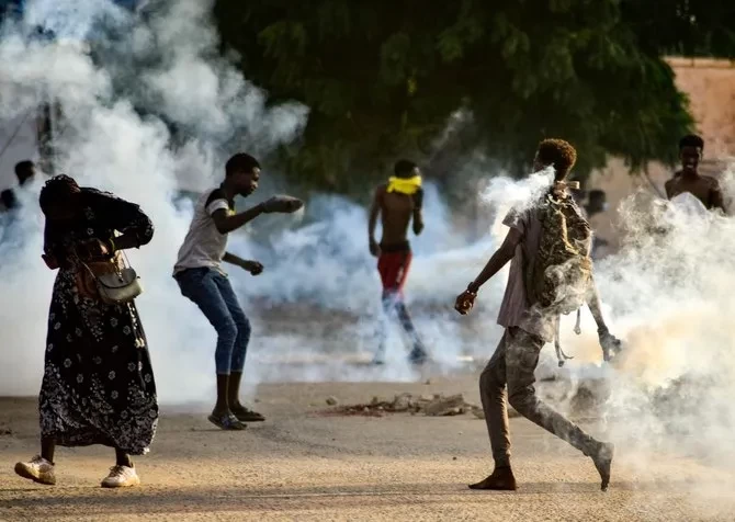 Pemuda Sudan menghadapi pasukan keamanan di tengah gas air mata yang ditembakkan oleh mereka untuk membubarkan pengunjuk rasa di Khartoum pada 27 Oktober 2021. (Foto: AFP)