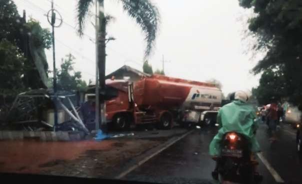 Truk tangki BBM seruduk mobil pikap parkir mengakibatkan dua warung dan bangunan pos keamanan di tepi jalan raya Bondowodo-Sirubondo Kecamatan Tapen Bondowoso rusak. (foto: satlantas polres)