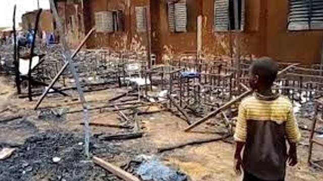 Seorang anak menatap puing-puing setelah ruang kelas terbakar di Maradi, Niger, Senin kemarin. Sebanyak 26 murid meninggal terbakar. (Foto:Africanews)