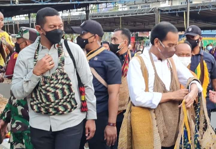 Presiden Jokowi sibuk dengan Noken yang baru dibeli untuk oleh-oleh dari Papua. (Foto: Setpres)
