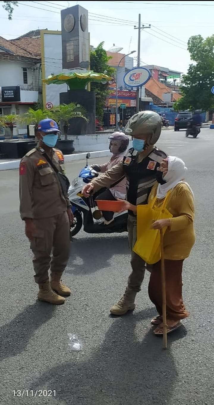 Satpol PP Kota Pasuruan menuntun seorang pengemis yang beroperasi di sekitar Jalan Panglima Sudirman Kota Pasuruan (Dok Satpol PP Kota Pasuruan)
