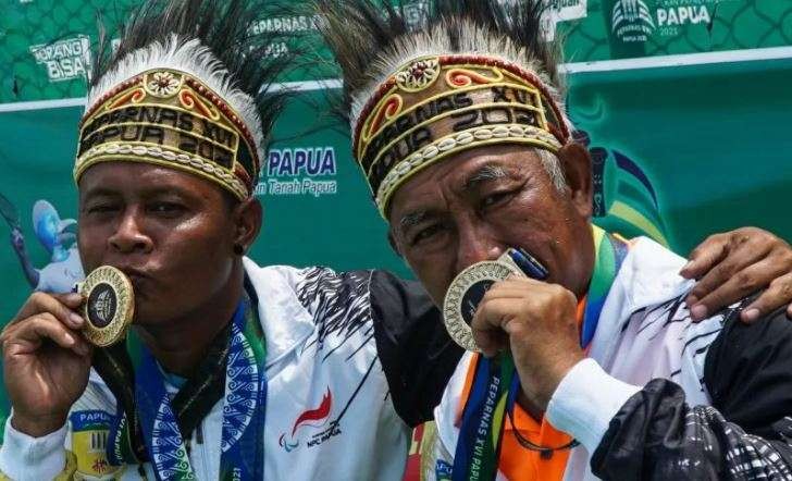 Petenis Papua Daryoko (kiri) dan Erwin Subrata (kanan) berpose usai menerima medali emas ganda putra quad Nasional tenis kursi roda Peparnas Papua di Sian Soor, Jayapura, Papua, Sabtu 13 November 2021.  (Foto: Antara/Indrayadi TH)