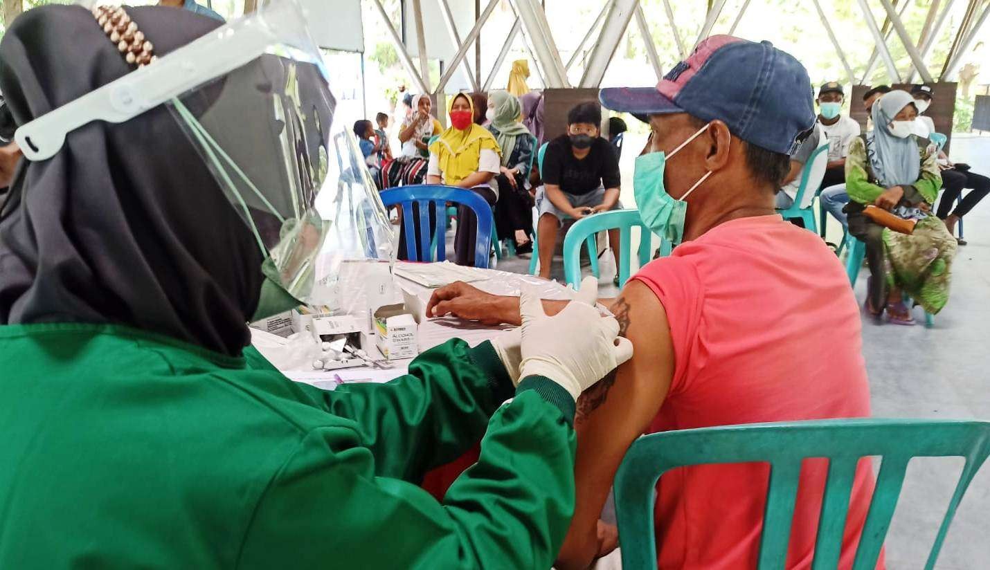 Salah seorang warga sedang disuntik vaksin Covid-19 dalam kegiatan vaksinasi yang digelar di Destinasi Wisata Pantai GWD (foto:Muh Hujaini/ngopibareng.id)