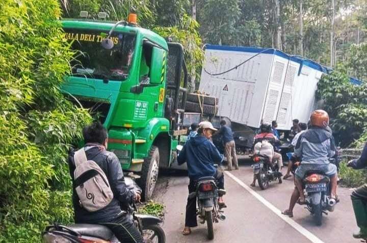 Truk trailer milik PT Medco terperosok melintang menutupi ruas jalan utama Bondowoso menuju kawasan wisata Kawah Ijen Sempol. (foto:satlantas Bondowoso)