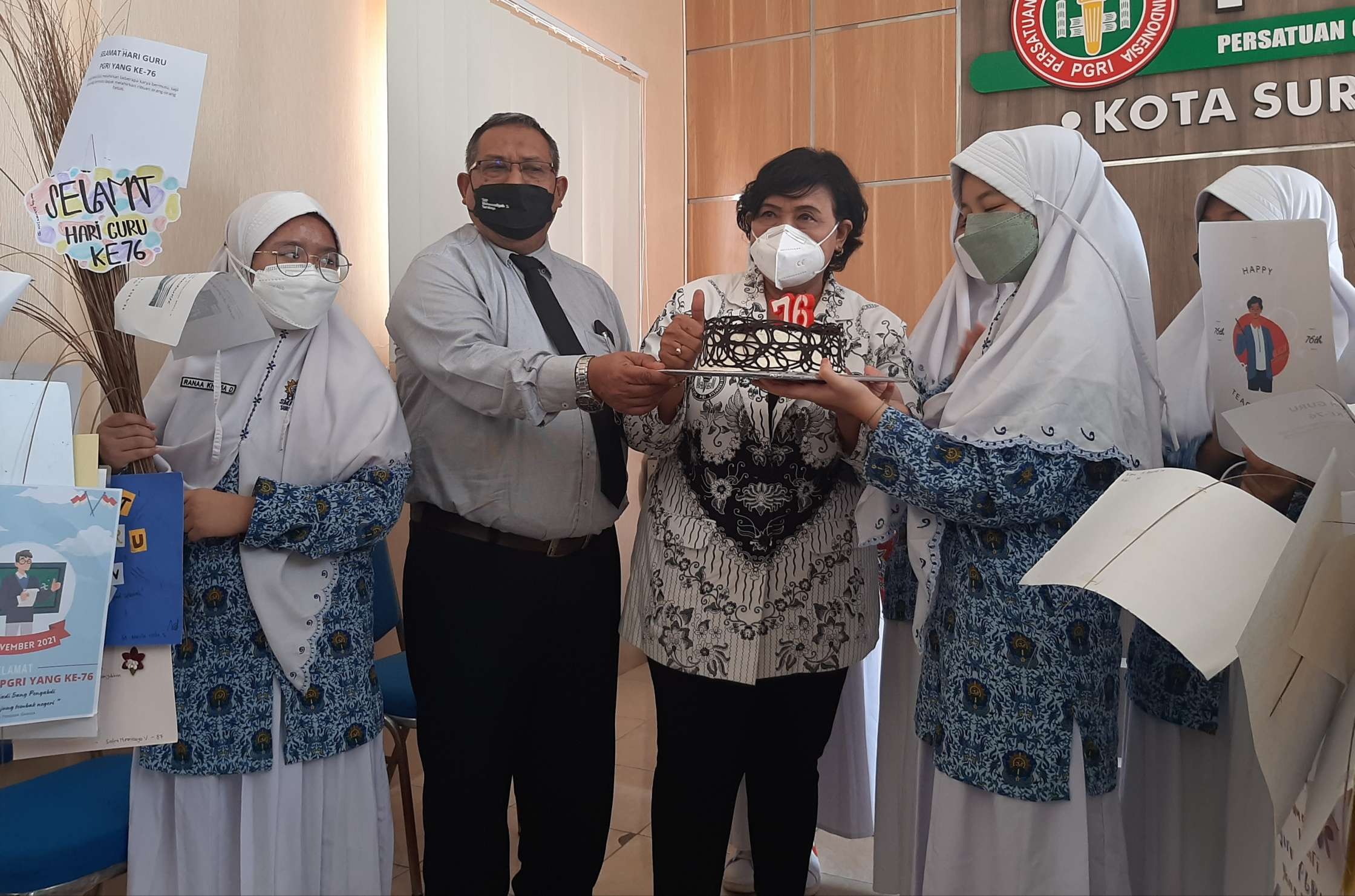 Ketua PGRI Surabaya, Agnes Warsiati saat menerima kue dari siswa SMP Muhammadiyah 5 Surabaya sebagai simbol perayaan HUT ke-76 PGRI. (Foto: Pita Sari/Ngopibareng.id)