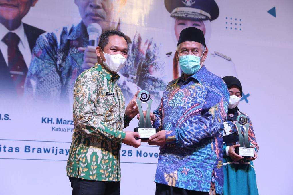 Bupati Lumajang, Thoriqul Haq terima penghargaan sebagai 'Tokoh Inspiratif Peduli Pesantren' yang diberikan secara langsung oleh, KH. Marzuki Mustamar. (Foto: Kominfo Lumajang)