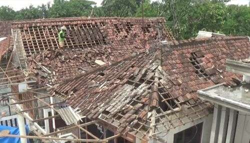 Warga Jombang membenahi atap rumahnya yang rontok diterjang angin. (Foto: Ant)