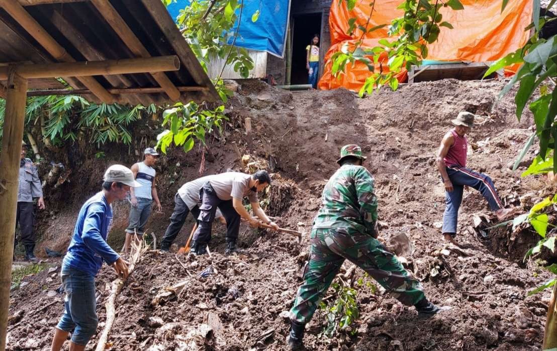 Personil TNI, Polri, dan BPBD Bondowoso bekerjasama mengevakuasi material longsor di Desa Gadingsari Kecamatan Pakem Bondowoso.(foto:guido/ngopibareng.id)