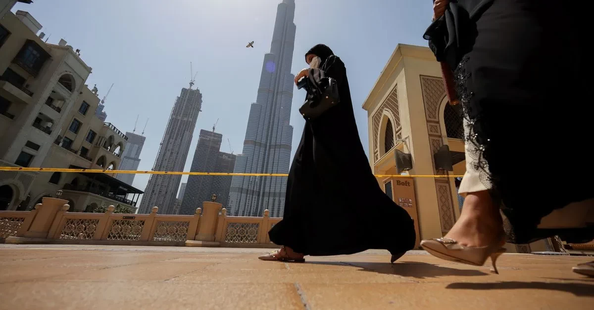 Dua orang perempuan berjalan di depan Burj Khalifa Dubai Uni Emirat Arab (Foto:Reuters)
