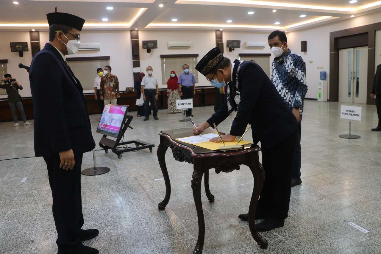 Prof. M. Arief Amrullah menandatangani dokumen pelantikan disaksikan Rektor Unej. (Foto: Dok Humas Unej)
