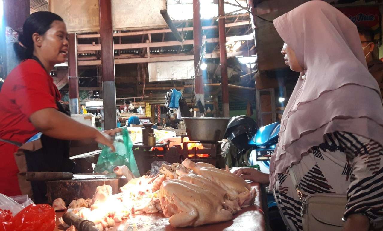 Seorang pedagang daging ayam di Pasar Baru, Kota Probolinggo. Menjelang Nataru, harga sembako naik. (Foto: Ikhsan Mahmudi/Ngopibareng.id)