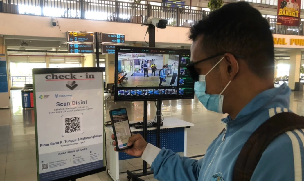 Penumpang bus di Terminal Purabaya alias Bungurasih melakukan scan barcode. (Foto: Andhi Dwi/Ngopibareng.id)