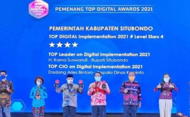 Bupati Situbondo Karna Suswandi (berkopiah) dan Kepala Diskominfosan, Dadang Aries Bintoro (tengah) saat malam penghargaan Top Digital Awards 2021 di Jakarta,  Selasa malam, 21 Desember 2021. (Foto: Humas Situbondo)
