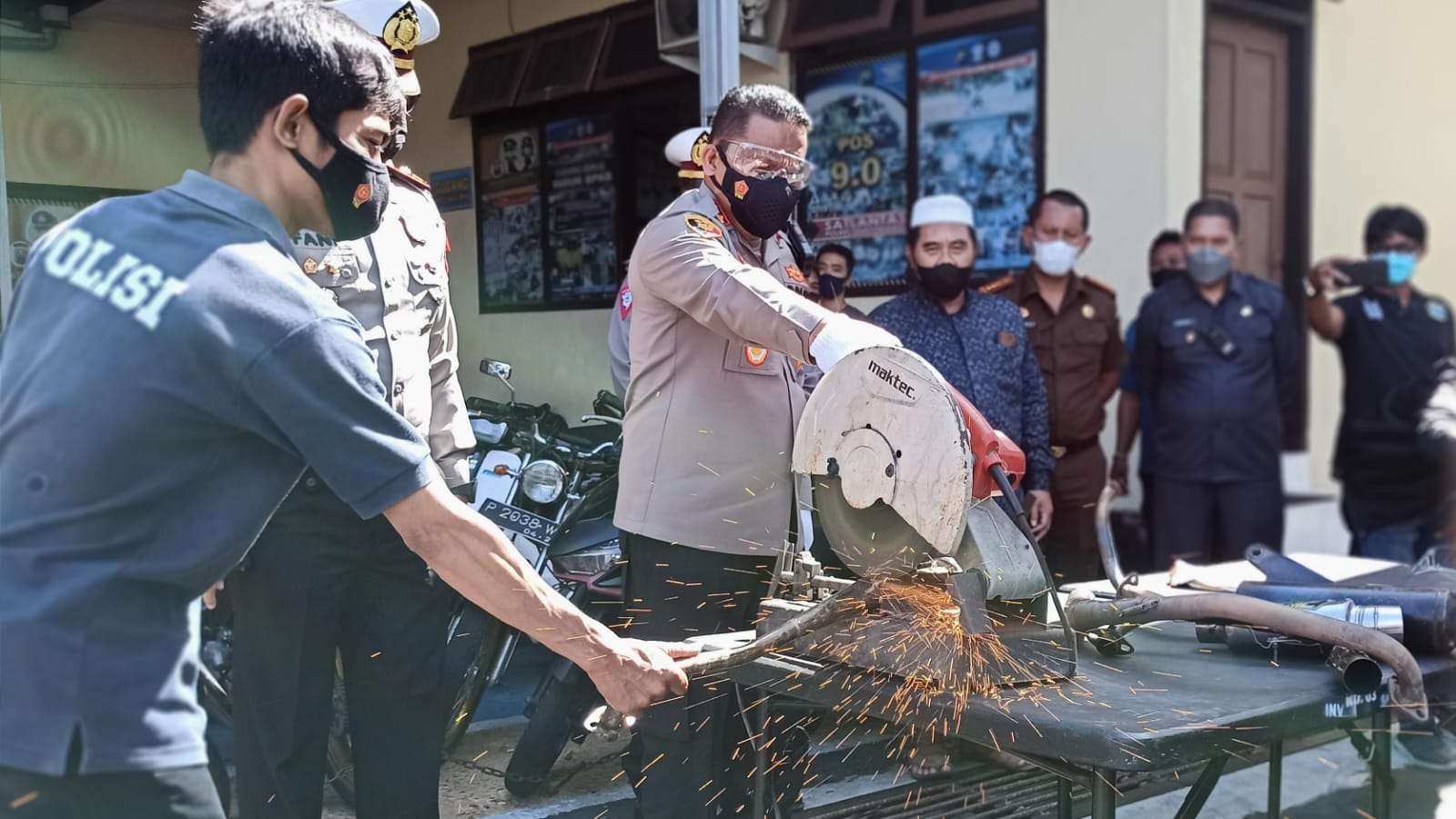 Kapolresta Banyuwangi AKBP Nasrun Pasaribu memotong knalpot brong dengan menggunakan gerinda (foto: Muh Hujaini/Ngopibareng.id)