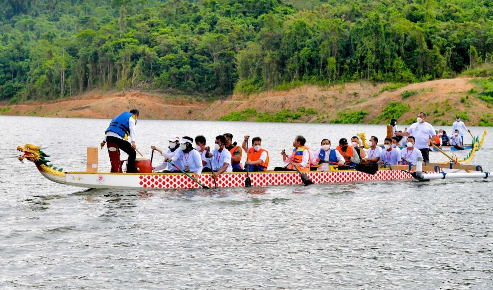 Presiden Jokowi bersama beberapa menteri mendayung perahu naga di Waduk Ladingi yang akan diresmikan. (Foto: Setpres)