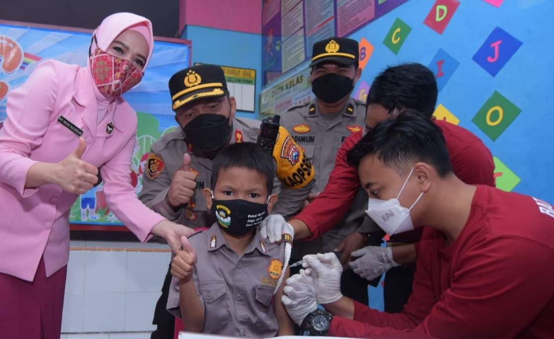 Kapolresta Banyuwangi AKBP Nasrun Pasaribu bersama Ketua Bhayangkari Cabang Banyuwangi memberi semangat salah satu anak yang menjalani vaksinasi Covid-19 (foto: istimewa)