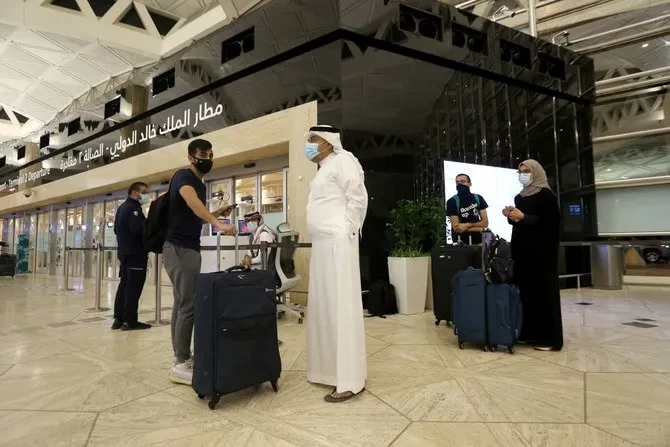 Warga Saudi menjaga jarak social, menunggu giliran mereka untuk check-in tas mereka di Bandara Raja Khalid International di Riyadh, Arab Saudi, 16 Mei 2021. (Foto: Reuters)