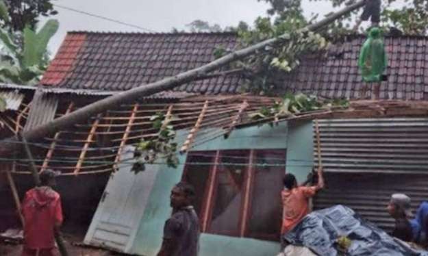 Warga bergotong royong memotong pohon tumbang dan membersihkan bangunan rumah yang rusak di Mlandingan Situbondo. (foto:bpbd situbondo)