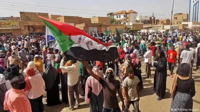 Seorang demonstran Sudan mengibarkan bendera nasional dalam aksi protes di Khartoum menentang kudeta militer Oktober 2021. (Foto: dw.com)