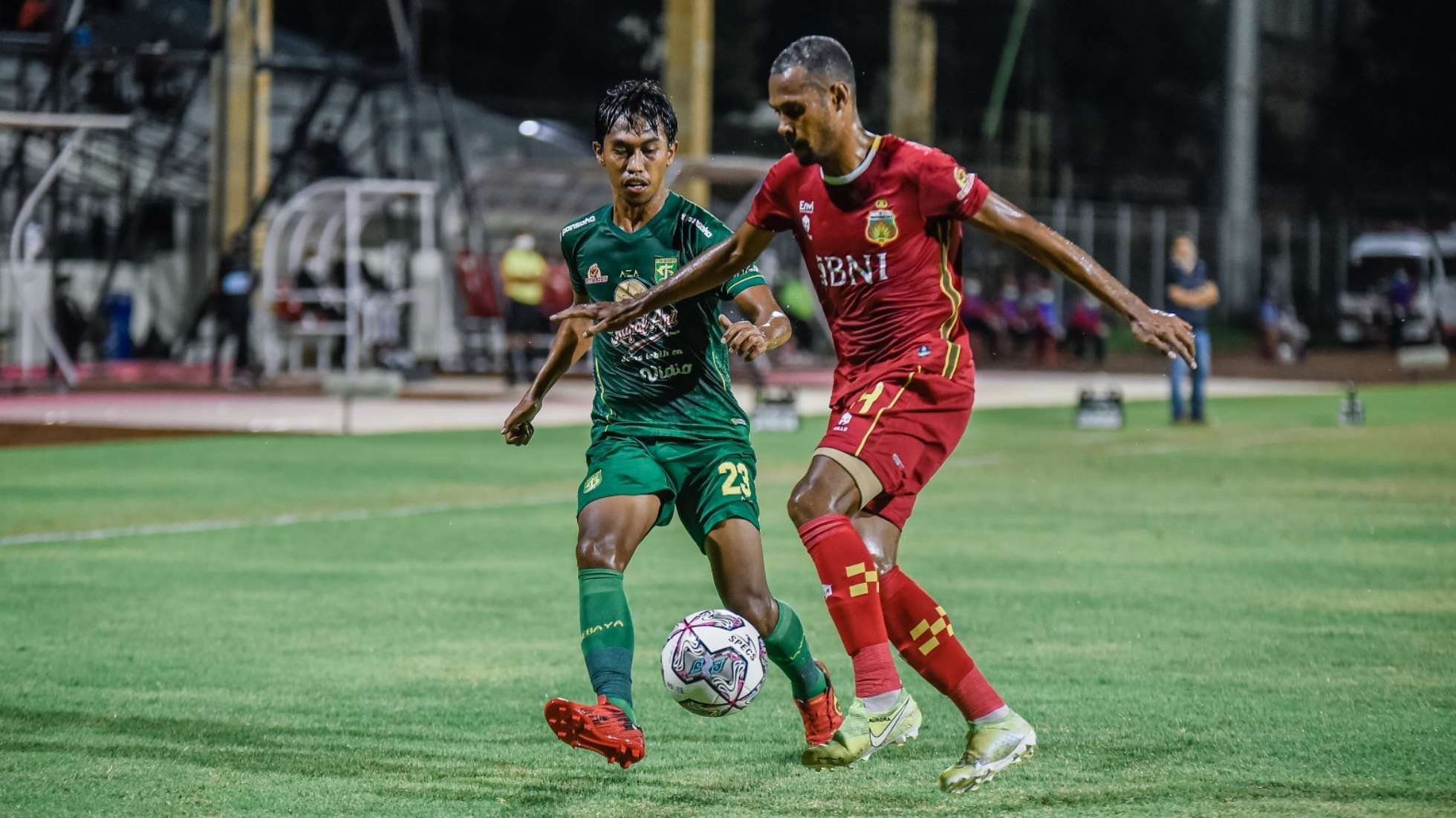Pemain Persebaya Ady Setiawan (hijau) berebut bola dengan pemain Bhayangkara FC, Ruben Sanadi pada pertandingan yang berlangsung di Stadion I Gusti Ngurah Rai, Denpasar, Selasa 18 Januari 2022 malam. (Foto: Istimewa)