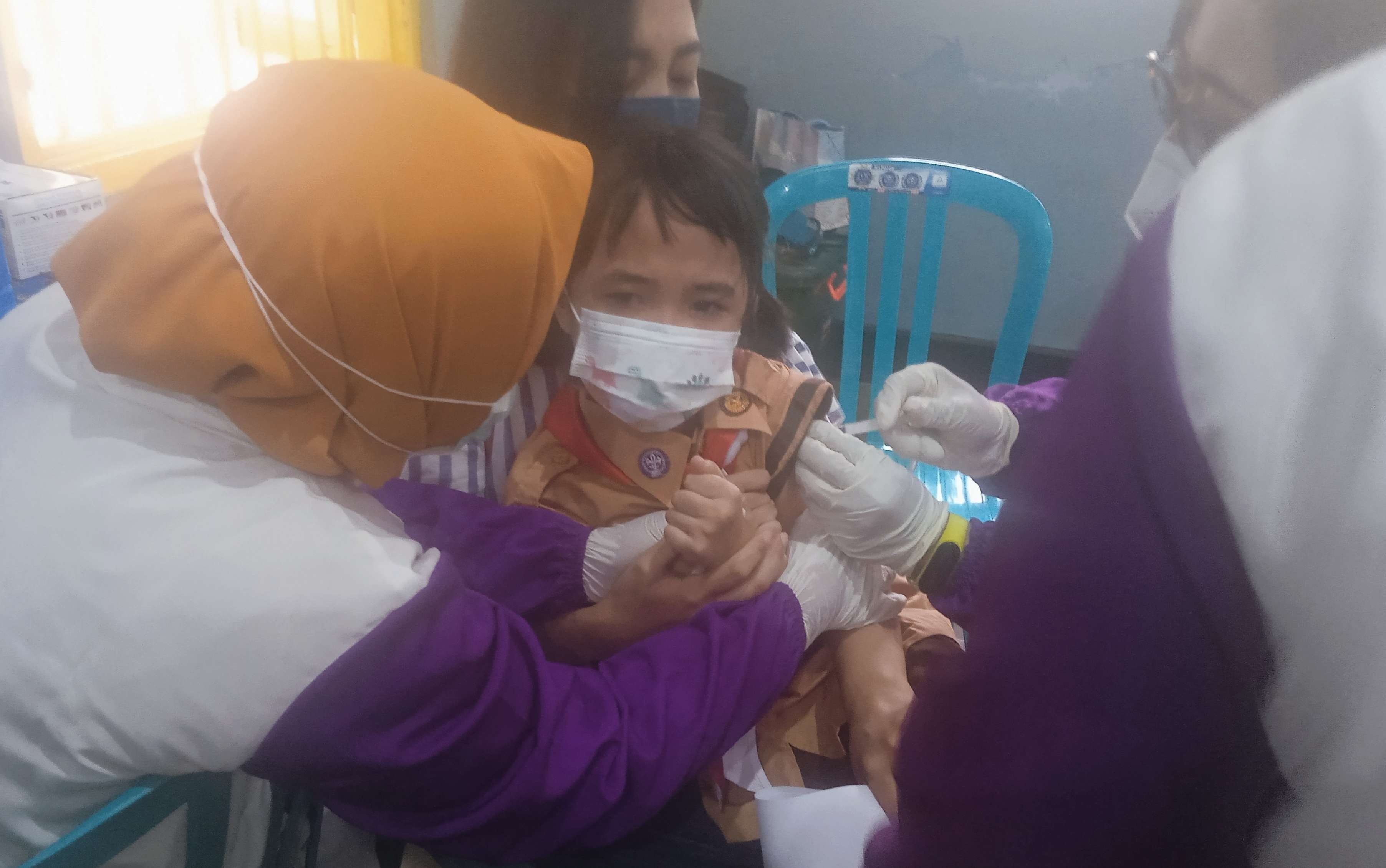 Sempat takut dan nangis, siswa SDK Indra Siswa Bondowoso mengaku disuntik vaksin Covid-19 tidak terasa sakit. (Foto: Guido Saphan/Ngopibareng.id)