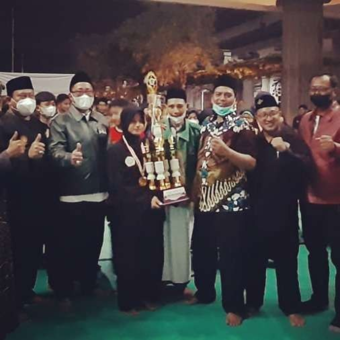 Perwakilan atlet Silat Kontingan Genuk memegang Piala Bergilir Juara Umum, diapit para tokoh dan pengurus Pagar Nusa Kota Semarang. (Foto: Istimewa)