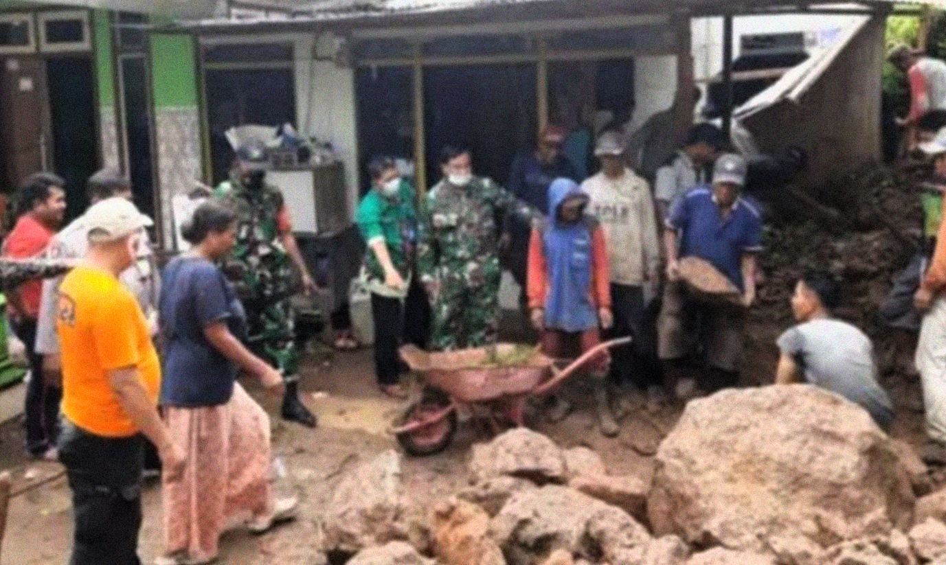 Warga gotong royong membersihkan material tanah dan bebatuan besar yang menimpa rumah Kennil warga Desa Selomukti Kecamatan Mlandingan Situbondo.(foto:bpbd situbondo)