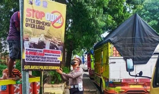 Satlantas Polres Situbondo memasang banner larangan truk atau angkutan barang melebihi dimensi dan muatan melewati jalan raya pantura. (Foto: Satlantas Polres Situbondo)