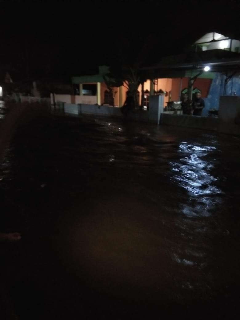 Jalan penghubung dua desa, Dringu dengan Kedungdalem, Kecamatan Dringu, Kabupaten Probolinggo berubah menjadi sungai, Minggu malam. (Foto: Ikhsan Mahmudi/Ngopibareng.id)
