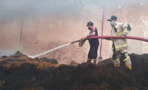 Petugas Damkar Satpol PP dan Damkar Bondowoso memadamkan api menghanguskan ratusan ton tembakau siap jual di gudang penyimpanan yang terbakar.(foto: guido/ngopibareng.id)