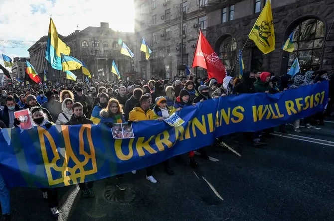Ribuan warga Ukraina mengadakan aksi demonstran. Mereka meneriakkan slogan-slogan saat mereka berbaris di belakang spanduk bertuliskan "Ukraina akan melawan" dalam rapat umum di Kyiv pada hari Sabtu. (Foto: ArabNews)