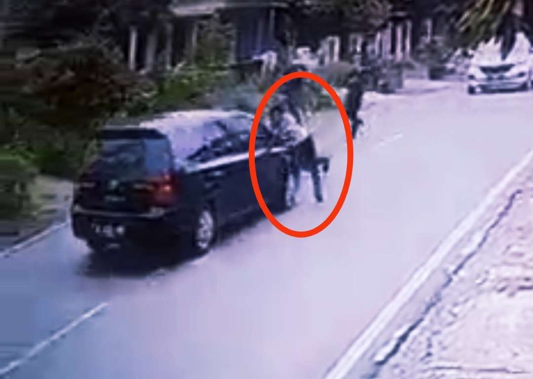 Anggota Satreskoba Polres Mojokerto berusaha menahan mobil tersangka dengan naik kap mobil. (Foto: Tangkap layar video rekaman CCTV)