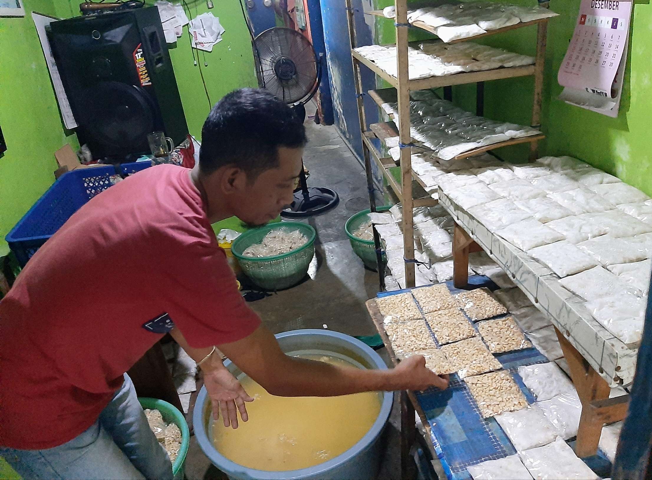 Jarwo Susanto saat memproduksi tempe di rumahnya daerah Putat Jaya, Surabaya. (Foto: Pita Sari/Ngopibareng.id)
