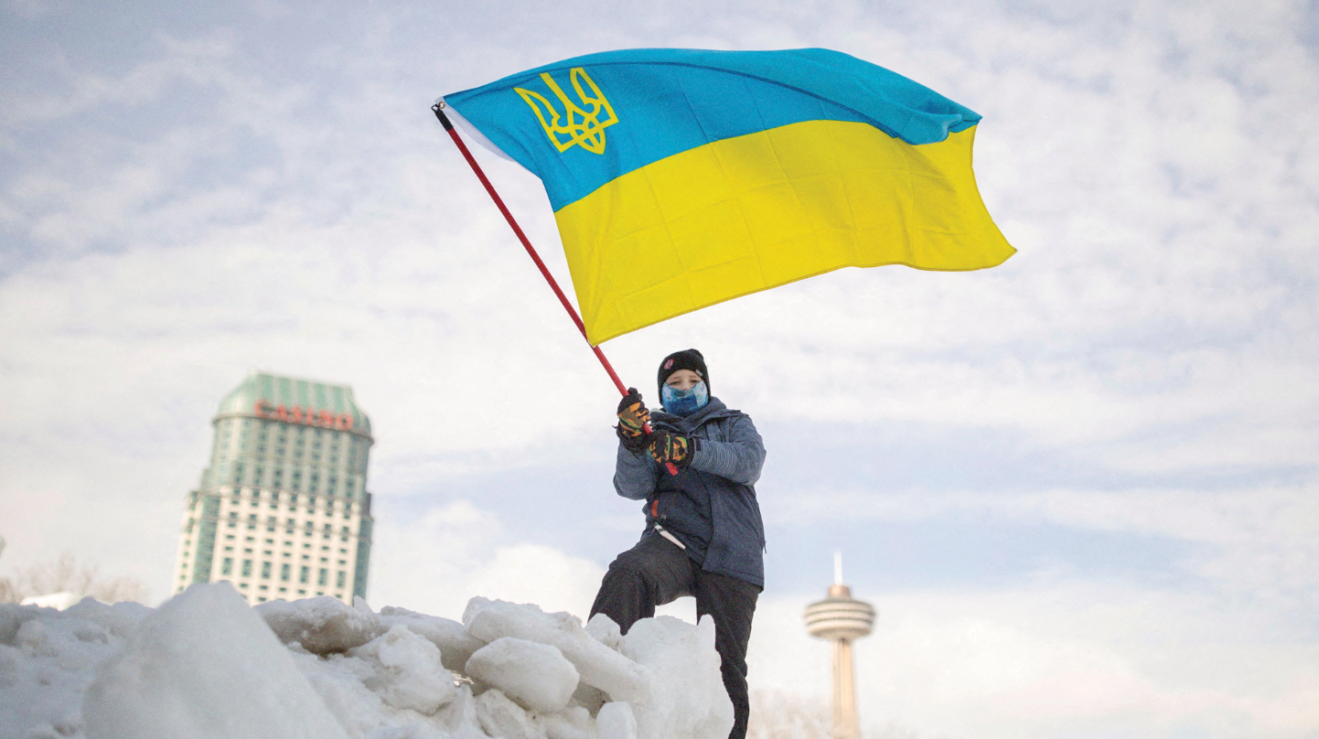 Seorang anak lelaki mengibarkan bendera Ukraina saat reli mendukung Ukraina dan memprotes Rusia, di Air Terjun Niagara, Kanada, Minggu 30 Januari 2022. (Foto:cfo)