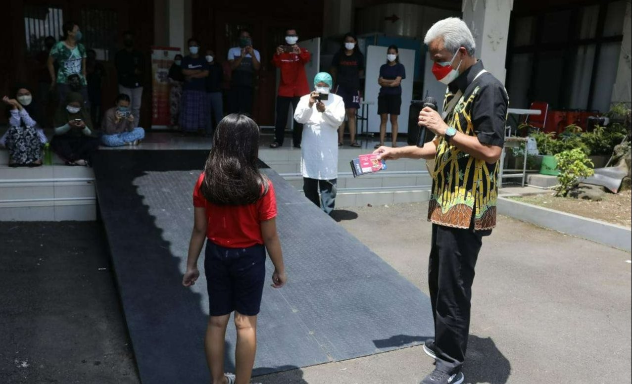 Gubernur Jawa Tengah, Ganjar Pranowo, beri HP kepada anak kelas 2 SD yang terpapar Covid-19. (Foto: dok. Humas Pemprov Jateng)