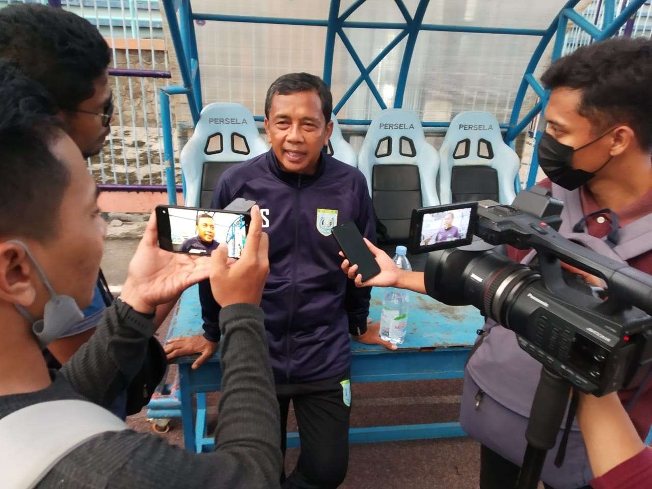 Coach Jafri Sastra diwawancarai sejumlah wartawan usai melatih di Stafion Surajaya Lamongan. (foto: Imron Rosidi/Ngopibareng.id)