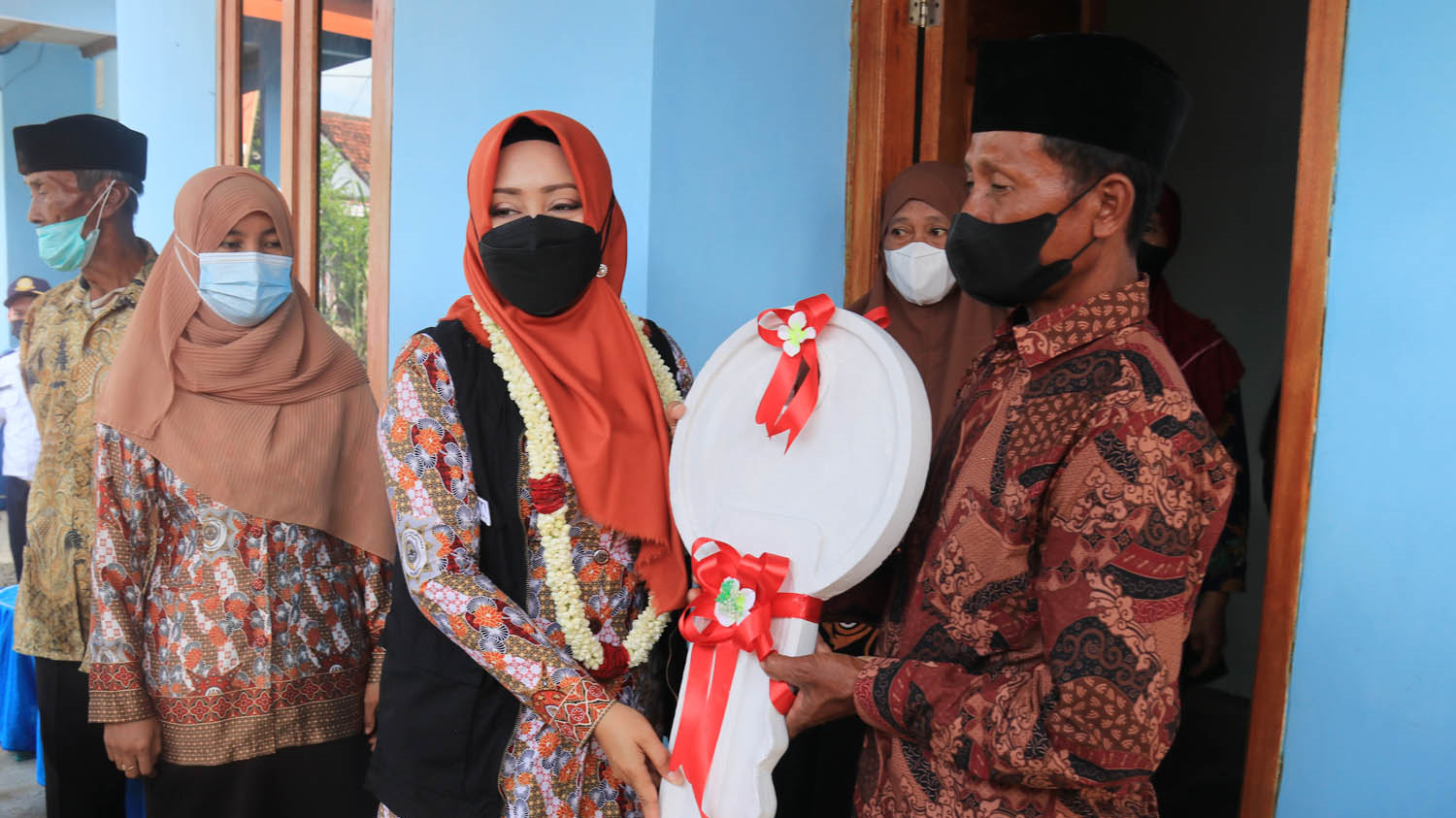 Bupati Mojokerto Ikfina Fahmawati menyerahkan secara simbolis replika kunci rumah kepada warga penerima bantuan bedah rumah, Kamis 24 Februari 2022. (Foto: Diskominfo Kabupaten Mojokerto)