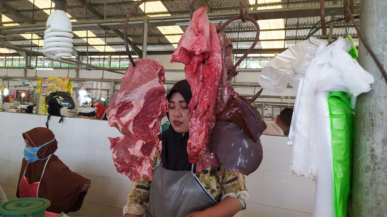 Pedagang daging sapi di Pasar Rakyat Sukomulyo Lamongan mengaku kenaikan harga daging sapi masih belum berpengaruh pada penjualan. (Foto: Imron Rosidi/Ngopibareng.id)