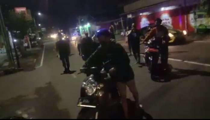 Sebanyak 22 pemuda yang terjaring razia diminta mendorong sepeda motornya menuju Polsek Patrang (Foto: Istimewa)