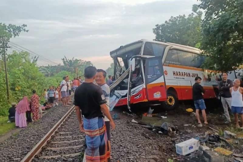 Bus Harapan Jaya ditabrak kereta api di Desa Ketanon,Kecamatan Kedungwaru, Tulungagung, Minggu, 27 Februari 2022. (Foto: Ant)